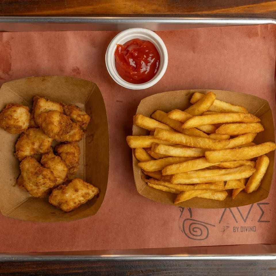 Crispy fried chicken nuggets, golden french fries, and a small cup of ketchup on a tray.